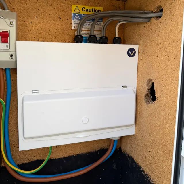A new consumer unit finished with its white cover and door fitted